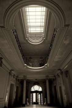 an empty building with two large windows and a skylight in the middle of it