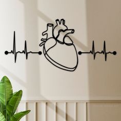 a metal heart on the wall next to a potted plant