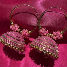 Beautiful pink and gold jhumka earrings. These earrings are light weight and can easily be dressed up or down. You can pair this with traditional wear. These Jhumkas have a vivid pink color which is intensified by the beautiful gold. These earrings also have beautiful beading. Cheap Bohemian Dangle Jhumkas, Affordable Wedding Jhumkas For Diwali, Cheap Festive Jhumkas With Latkans, Cheap Bohemian Jhumkas For Diwali, Temple Jewelry Style Jhumkas With Latkans For Party, Pink Jewelry With Matching Earrings For Festivals, Pink Jewelry For Party And Festivals, Chandbali Earrings With Bells For Festivals, Pink Bollywood Jewelry