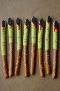 four long carrots with faces painted on them, all lined up in the same row