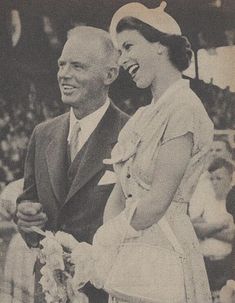 an old black and white photo of a man and woman standing next to each other