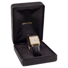 Tiffany & Co. 14k Yellow Gold Men's Hand-Winding Dress Watch w/ Original Box Movement #9255 Case #392906 14k Yellow Gold Square Case 26 mm Wide (27 mm w/ Crown) 27 mm Long Lug-to-Lug Distance = 37 mm Lug-to-Lug Width = 18 mm Thickness = 8 mm Champagne Art Deco Dial w/ Seconds Subdial Gold Tic Marks and Hands 23 mm Long x 23 mm Wide Black Leather Aftermarket Band w/ Gold-Plated Clasp Total Length = 8.25" Largest Wrist Fit = 7.75" Width at Case = 18 mm Width at Tip = 15 mm Total Mass = 29.3 grams Includes Original Tiffany & Co. Case Winding Dress, Champagne Art, Tiffany And Co, Dress Watch, Leather Band, Tiffany & Co., X 23, Leather Watch, Wrist Watch