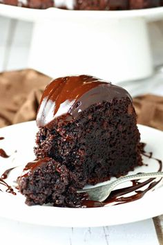 a piece of chocolate fudge bundt cake on a white plate with a fork