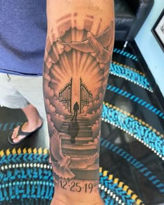 a person with a tattoo on their arm that has stairs leading up to a bridge