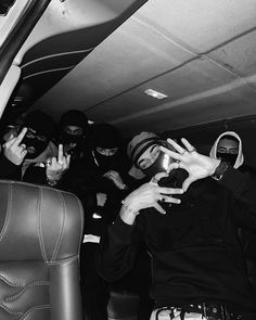 a group of people sitting in the back of a car holding up their cell phones