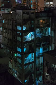 an apartment building at night lit up with blue light from windows and balconies