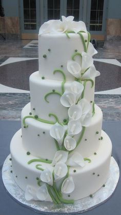 a three tiered cake with white flowers on it