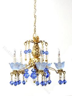 a chandelier with blue glass flowers and candles