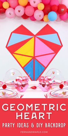 the geometric heart party table is set up with pink, yellow and blue balloons in the background