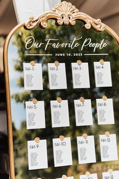 the seating chart for our favorite people is displayed on a gold framed easel with white cards attached to it