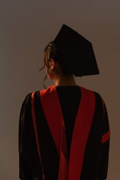 a woman wearing a black and red graduation gown