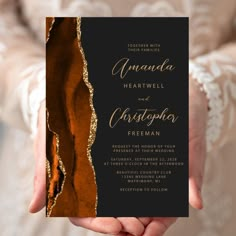 a person holding up a card with gold foil on the front and back of it