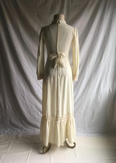 "1970s prairie dress label- Patty O'Neil cream color w/oatmeal specks cotton muslin feel lace trim- synthetic feel long sleeve w/button cuff v neck w/collar tie back from front high waist band zip up back w/hook eye top closure floor to ankle length, more or less depending on wearer's height very good vintage condition, light wear label size 7 (see below) fits like a modern small, please go by measurements measures, lying lat, shoulder-13 3/4\" chest-17\" waist-13\" (26\" waist total) hip-21\" s Bohemian Cream Maxi Dress For Fall, Cotton Prairie Dress For Daywear, Cream Cotton Maxi Dress For Spring, Vintage Prairie Dress For Fall Daywear, Vintage Beige Prairie Dress, Fall Cotton Fitted Maxi Dress, Fall Cream Dress With Lace Trim, Cream Lace Trim Dress For Fall, Cream Cottagecore Dress For Fall