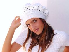 a woman wearing a white hat and posing for the camera