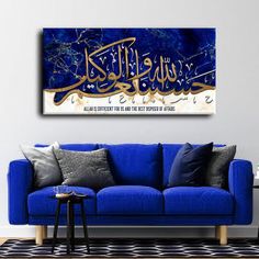 a living room with blue couches and arabic calligraphy on the wall above it