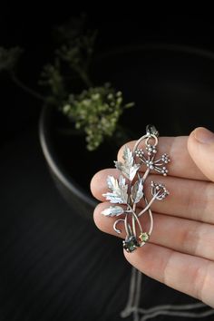 ITEM DESCRIPTION: The size H 5 cm x W 3 cm (2 x 1 1/3 inch). Weight - 5 g. You can buy it with a silver chain or without it. Even simple plants look very elegant. I made one of sterling silver, pretty green tourmaline, and peridot. This unique botanical jewelry looks like a real treasure of wild forest. It is really worthy of being in your precious collection. Expect many compliments on this! This handmade necklace will come to you in a gift box - ready for gifting. The parcel will be sent durin Green Sterling Silver Brooch, Sterling Silver Green Brooch, Green Sterling Silver Brooch Jewelry, Nature-inspired Silver Metal Necklace, Flower Pendant Brooch Jewelry Gift, Silver Nature-inspired Metal Jewelry, Nature-inspired Silver Metal Jewelry, Elegant Silver Jewelry With Birth Flower, Nature-inspired Sterling Silver Flower Jewelry