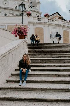 a woman sitting on some steps in front of a building