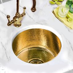 a gold sink in a white marble counter top