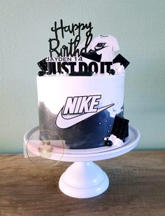 a birthday cake decorated with nike and happy birthday stickers