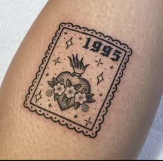 a small tattoo on the leg of a woman's thigh with flowers and a heart