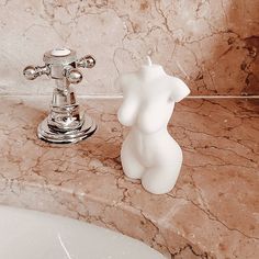 a white bear shaped soap dispenser next to a sink in a bathroom