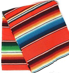 an orange and blue striped scarf laying on top of each other