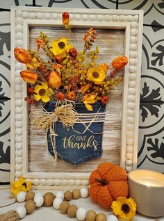 a vase filled with yellow flowers sitting next to a candle and some beads on a table