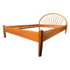 a wooden bed frame with curved headboard and foot board on the bottom part of it