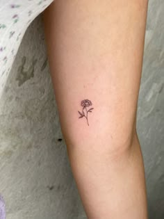 a small rose tattoo on the left thigh and right leg, with one flower in it's center