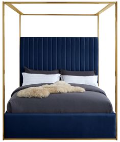 a bed with a blue velvet headboard and white pillows on the bottom, along with a gold frame