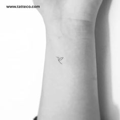 a small bird tattoo on the wrist is seen in this black and white photo,