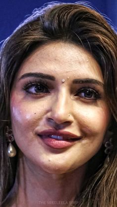 a close up of a person with long hair and piercings on her nose, wearing earrings