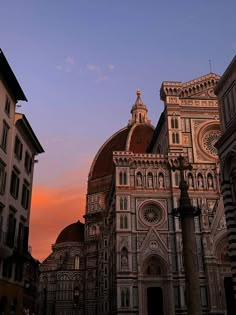 an image of a church that is in the middle of some buildings at sunset or dawn