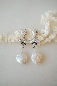 Our BELLE Freshwater Pearl Earrings are so unique and drop dead gorgeous. Made with white cubic zirconia and freshwater pearl, they're made to stand out. They were designed for the classic, yet bohemian chic bride. They add a beautiful touch to every bridal look!---------------------FEATURES◊ White cubic zirconia oval post (.925 sterling post, rhodium or gold plated)◊ Flat freshwater pearl ◊ Cubic zirconia fan pendant (rhodium/gold plated)◊ 100% nickel free, great for sensitive ears--> Get th Timeless Cubic Zirconia Wedding Earrings, Timeless Drop Earrings For Bridal, Timeless Silver Bridal Earrings For Weddings, Timeless Drop Bridal Earrings For Wedding, Timeless Wedding Drop Earrings, Timeless Dangle Bridal Earrings For Wedding, Timeless Teardrop Bridal Earrings For Wedding, Timeless Bridal Earrings With Pearl Drop, Timeless Pearl Drop Bridal Earrings For Wedding