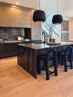 a kitchen island with stools in front of it and an open fireplace behind it