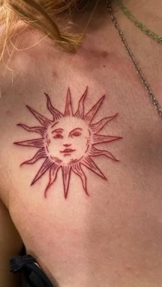 a woman's chest with a sun tattoo on the top and bottom part of her chest