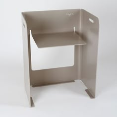 the corner shelf is made out of metal and has a white paper holder on it