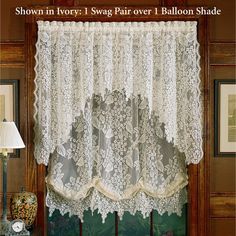 a window with lace curtains hanging on it's side and the words show in ivory i swag parr over balloon shade