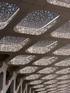 an intricately designed ceiling in the middle of a building with blue skies above it