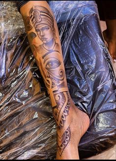 a person with a tattoo on their leg sitting next to a pile of plastic bags