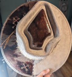 PRICE DROP ⬇️⬇️⬇️ Stiff brim taupe fedora with custom design cow pattern foil.  There is leather stitching and custom hat band with feather adornment.  Bold hat for turning heads! Custom Brown Hat Bands For Festival, Western Hats With Leather Lining And Flat Brim, Leather Fedora With Flat Crown For Rodeo, Leather Fedora With Flat Crown In Country Style, Distressed Brown Leather Fedora Hat, Custom Handmade Leather Hat Bands, Distressed Brown Leather Fedora, Leather Flat Crown Country Hat, Leather Hat With Flat Crown For Country Events