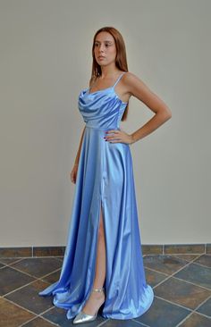 a woman in a blue dress posing for the camera with her hands on her hips