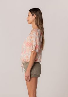 A charming short puff sleeve blouse in a natural and pink floral print. Floral print Cotton Relaxed fit Short puff sleeve Elastic cuff Scoop neckline Self-covered button front Adjustable drawstring waist with ties Lined Lightweight summer blouse Made with lightweight cotton, this spring blouse is perfect for any occasion. Designed in a pink floral print, with a scoop neckline and a relaxed fit. The short puff sleeves add a playful touch and make this blouse perfect for spring and summer. Model i Feminine Relaxed Fit Short Sleeve Tops, Summer Puff Sleeve Short Sleeve Top, Feminine Short Sleeve Top For Spring, Casual Puff Sleeve Top With Blouson Sleeves, Feminine Short Sleeve Tops For Daywear, Summer Puff Sleeve Top With Short Sleeves, Spring Floral Print Puff Sleeve Top, Feminine Pink Puff Sleeve Top For Summer, Feminine Short Sleeve Blouse With Relaxed Fit