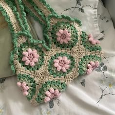 a crocheted purse sitting on top of a bed next to a white pillow