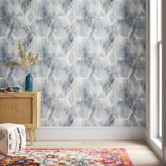 a blue and white wallpaper with an abstract design in the corner next to a dresser