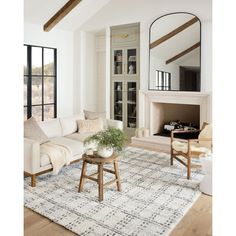 a living room filled with furniture and a fire place in front of a mirror on the wall