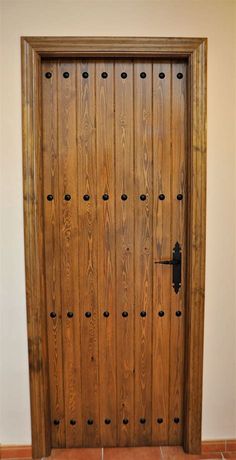 a wooden door with holes in the front and side panels on the outside, along with tile flooring