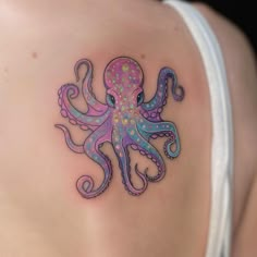 an octopus tattoo on the back of a woman's shoulder