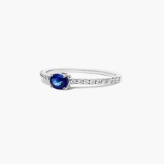 a blue sapphire and diamond ring on a white background