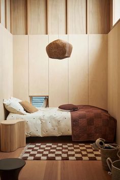 a bedroom with wood paneling and a checkered rug